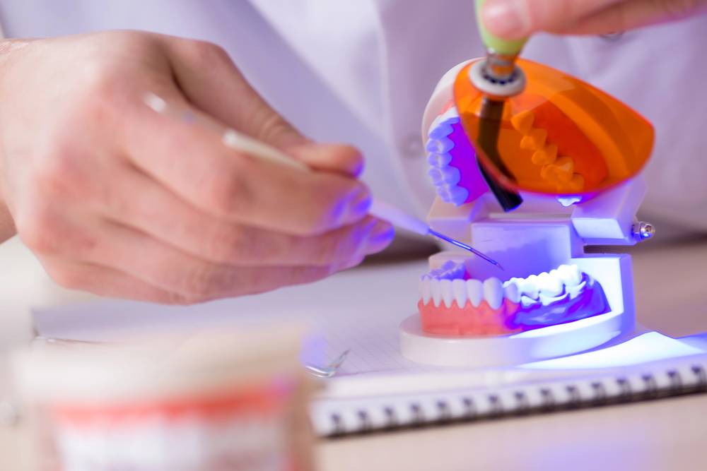 Dentist working teeth implant in medical lab